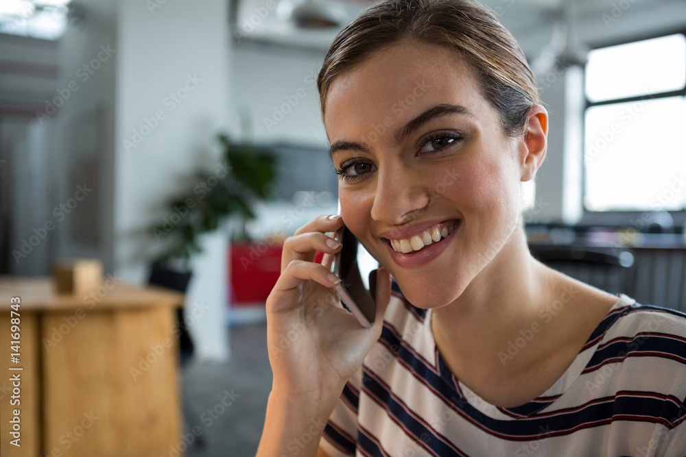 Smiling female graphic designer talking on mobile phone Smiling female graphic designer talking on mobile phone