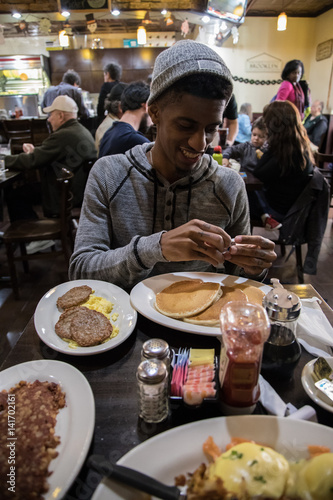 A young  hip man eats brunch at Brooklyn  NYC diner