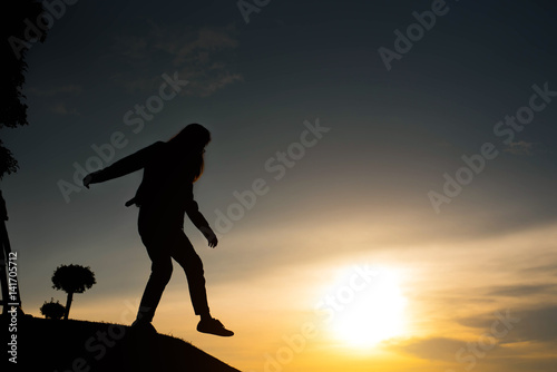 Fototapeta Naklejka Na Ścianę i Meble -  woman silhouette standing looking to sky at sunset
