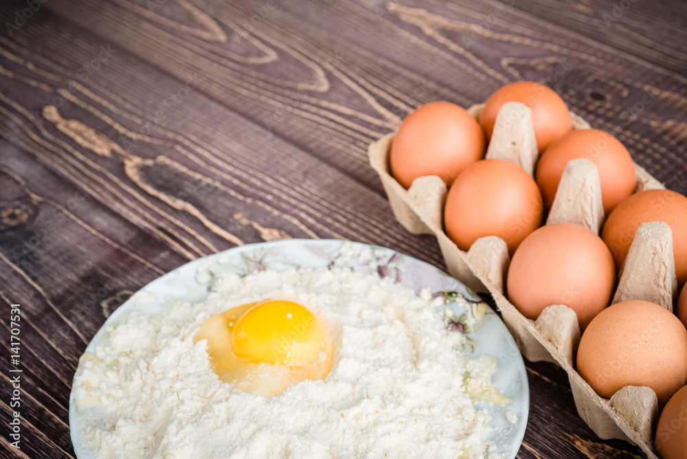 Eggs and flour on a wooden background, baking background Eggs and flour on a wooden background, baking background