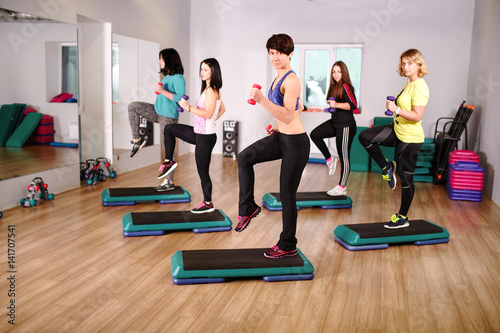 fitness group of smiling women training in gym