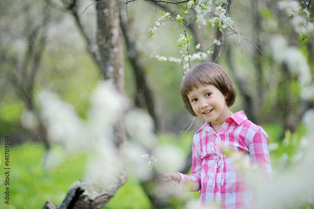 Adorable little girl having fun in blooming cherry garden on beautiful spring day Adorable little girl having fun in blooming cherry garden on beautiful spring day