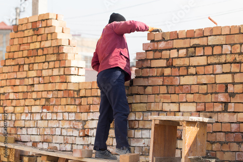 Worker builds a brick wall in the house