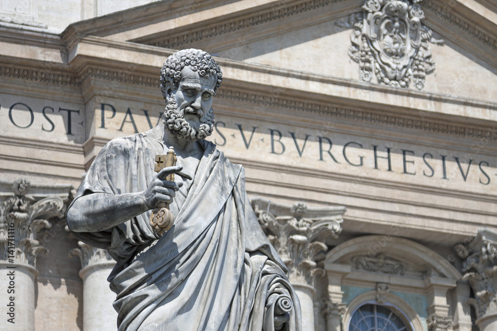 Vatican (Rome, Italy). Statue of Saint Peter with key in hand and St Peter's Basilica at blurred background on St Peter's Square