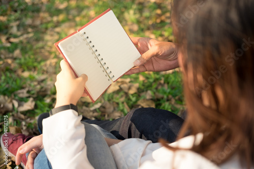 couple holding diary with vinte color in the garden