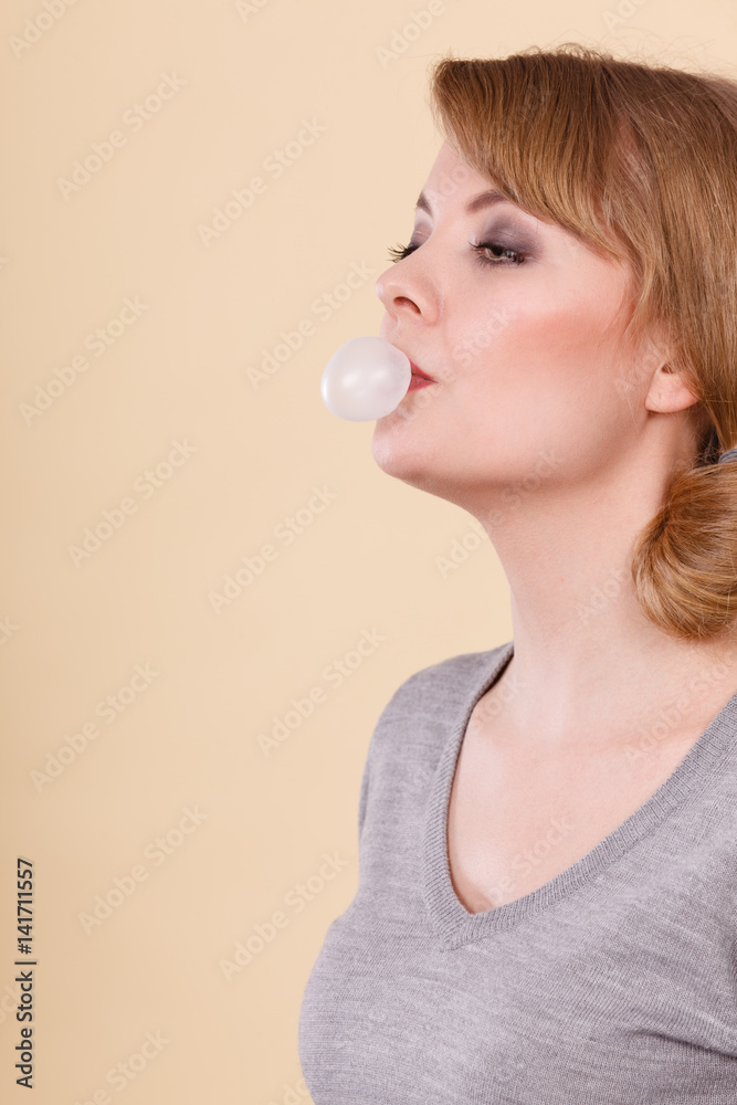 Blonde girl chewing gum making balloon. Blonde girl chewing gum making balloon.