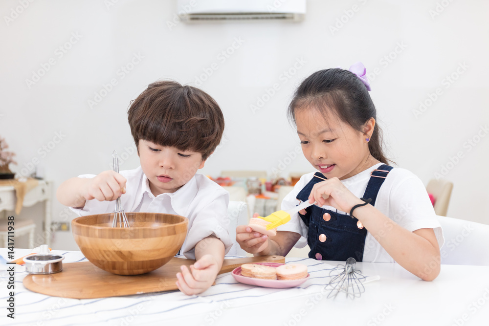 Asian Chinese little brother and sister preparing to bake cookies Asian Chinese little brother and sister preparing to bake cookies
