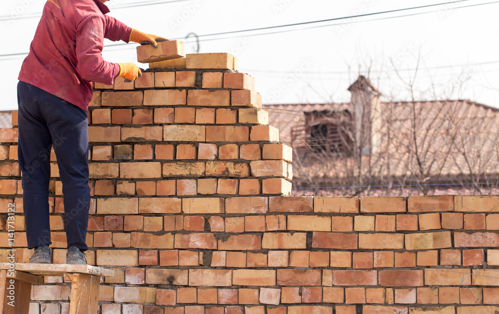 Worker builds a brick wall in the house Worker builds a brick wall in the house