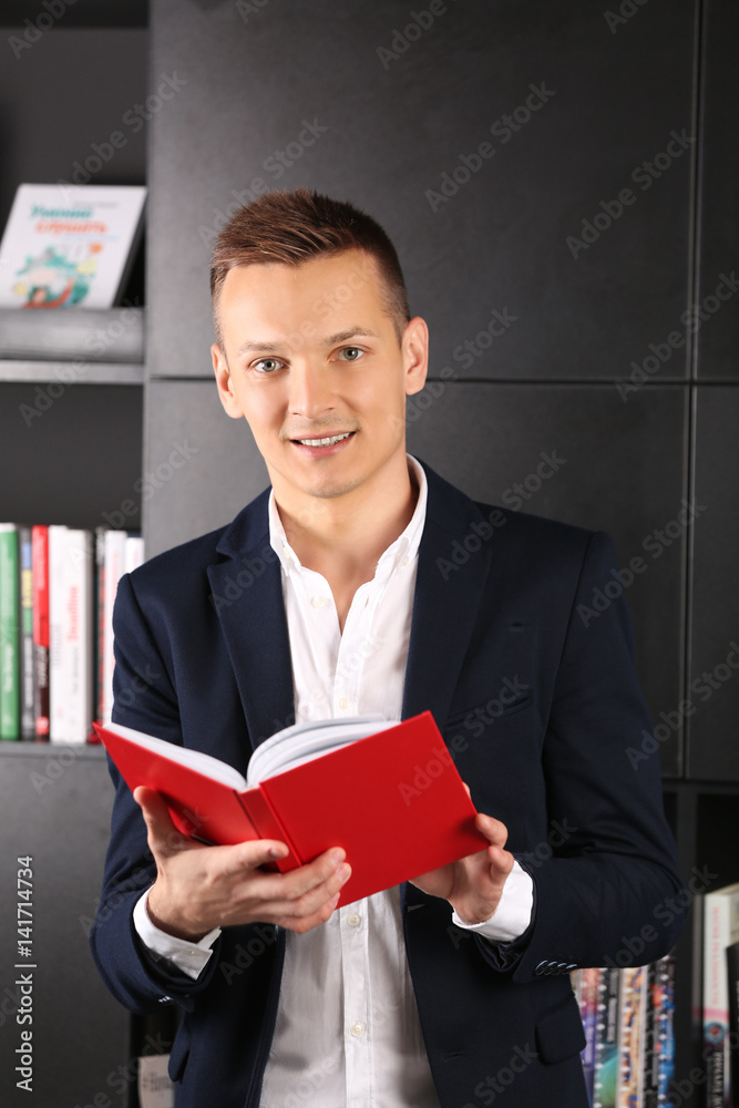 Handsome man reading book in library