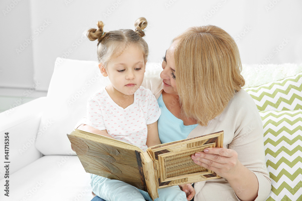 Grandmother looking at photo album with her grandchild Grandmother looking at photo album with her grandchild