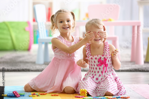 Adorable little sisters pla...