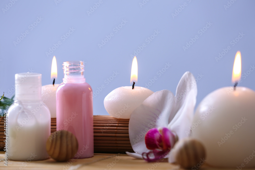 Spa composition with candles on color background