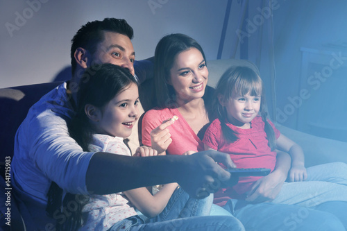 Happy family watching TV on...