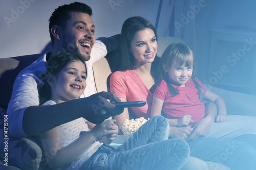 Happy family watching TV on...