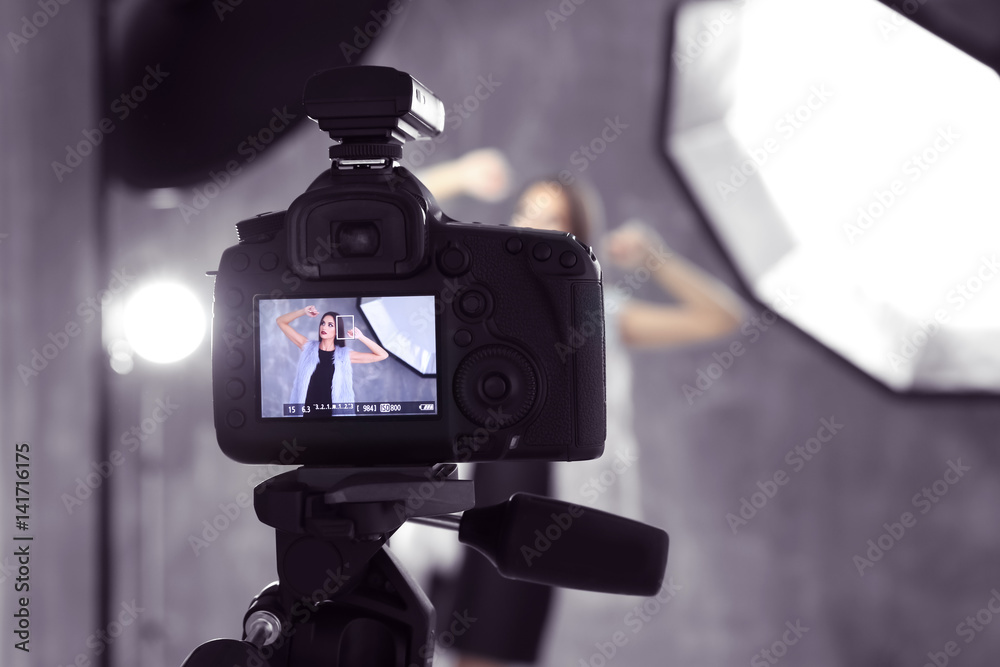 Picture of young beautiful model on camera display while shooting
