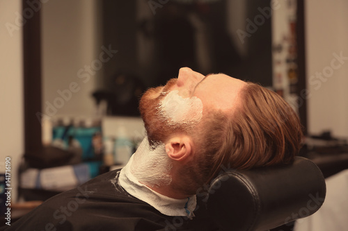 Hairdresser shaving client ...