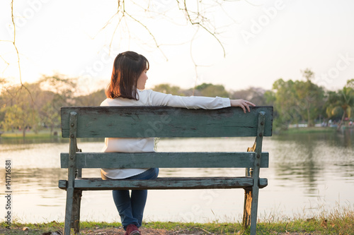 alone girl sitting on bench in the garden
