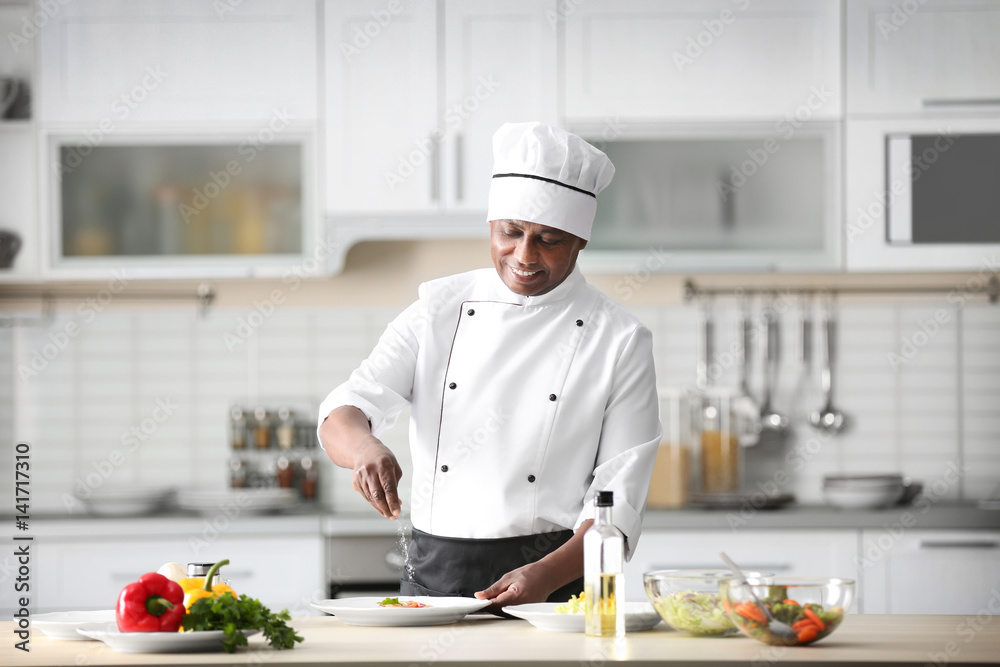 Mature Indian chef cooking in kitchen Mature Indian chef cooking in kitchen
