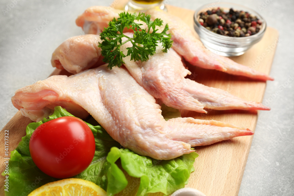 Raw chicken wings with spices on cutting board Raw chicken wings with spices on cutting board