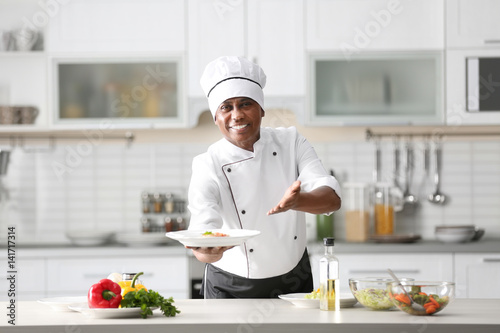 Obraz na plátně Mature Indian chef cooking in kitchen