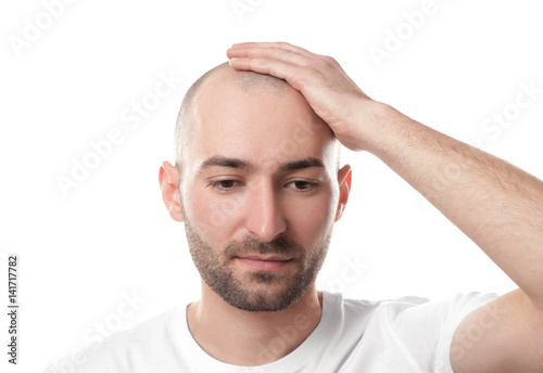 Fototapeta Naklejka Na Ścianę i Meble -  Hair loss concept. Man touching his bald head on white background