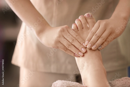 Young woman having foot treatment in spa salon