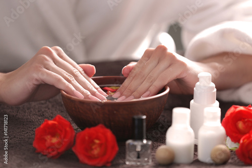 Young woman having hand treatment in spa salon