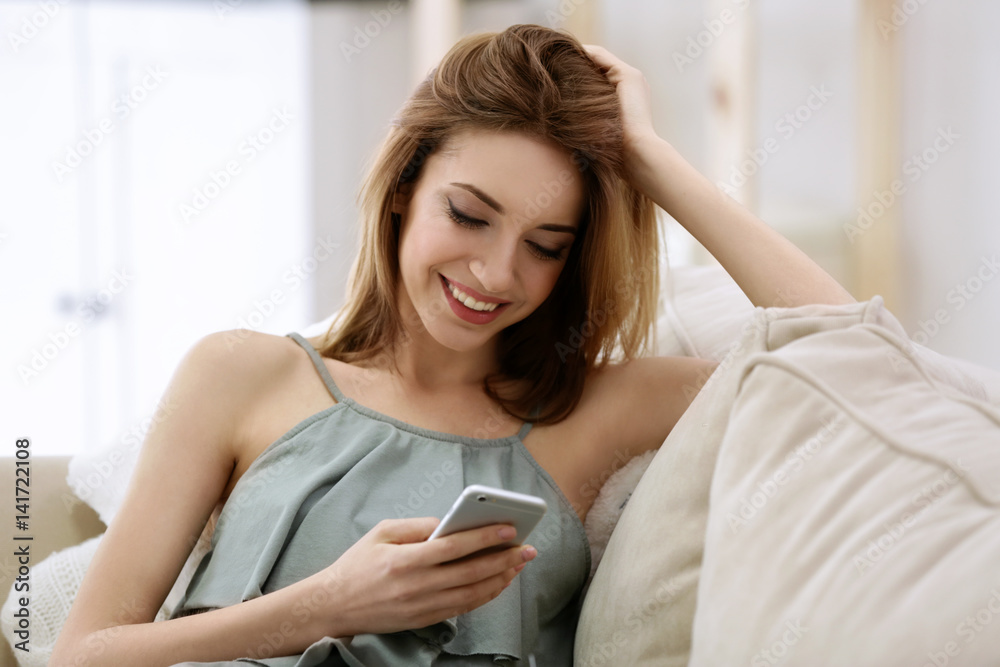 Beautiful young woman with mobile phone at home Beautiful young woman with mobile phone at home