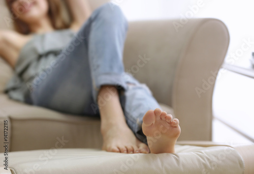 Feet of beautiful young woman resting at home, closeup
