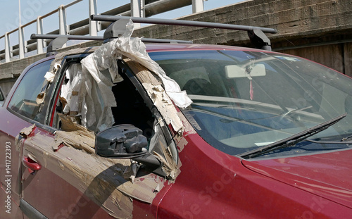 Car badly damaged and abandoned on the road. photo