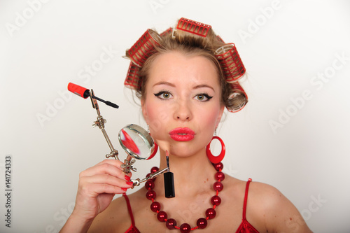 A housewife with hair-curlers and with a magniglass photo