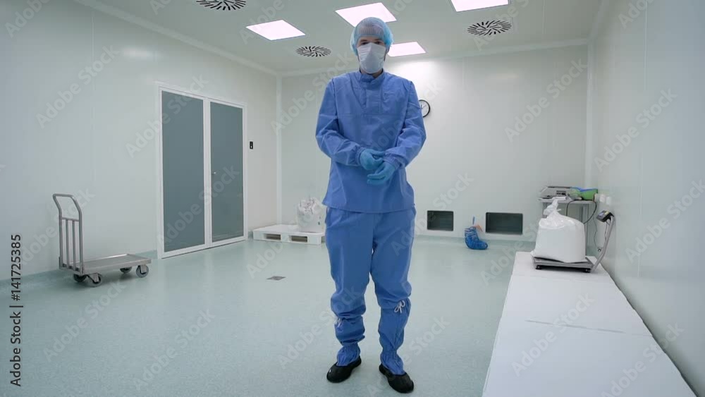 A man working in a clean room, pharmaceutical enterprise. Specialist in a protective suit, gloves, glasses and a mask. A man working in a clean room, pharmaceutical enterprise. Specialist in a protective suit, gloves, glasses and a mask.