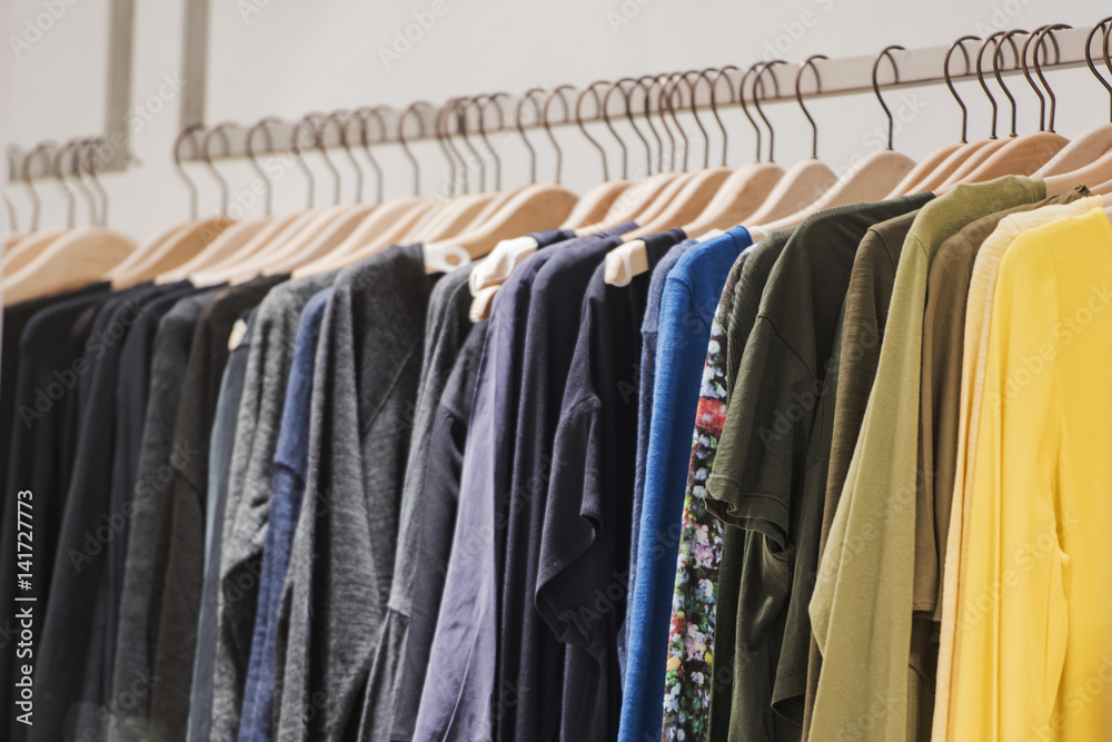 Fancy clothing hanging on racks in a store Fancy clothing hanging on racks in a store