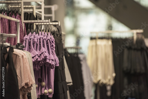 Fancy clothing hanging on racks in a store © agcreativelab