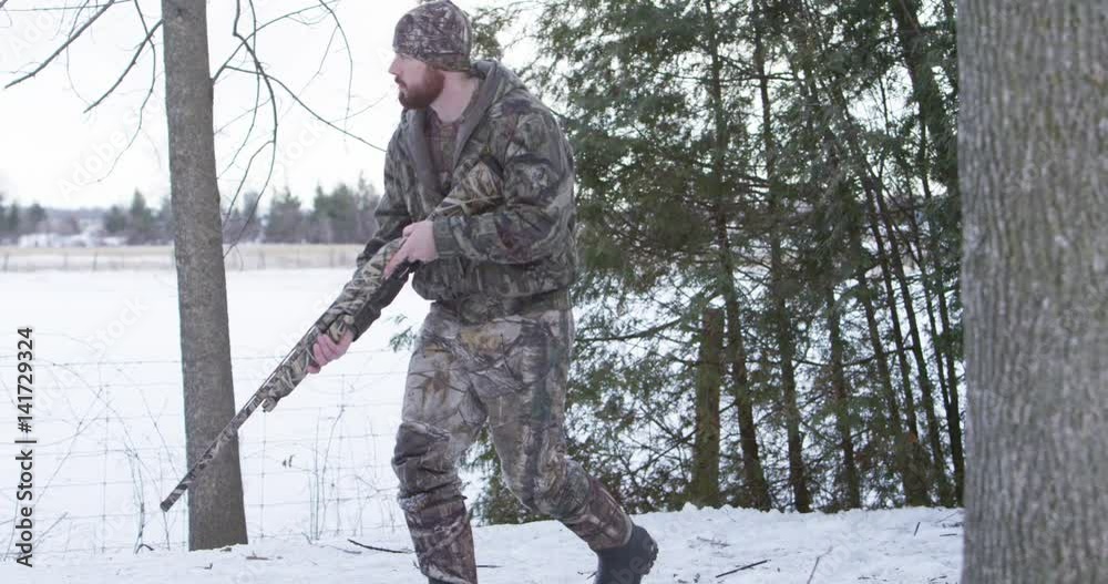 hunter searching for prey in winter stops to take aim with shotgun slow motion 4k hunter searching for prey in winter stops to take aim with shotgun slow motion 4k