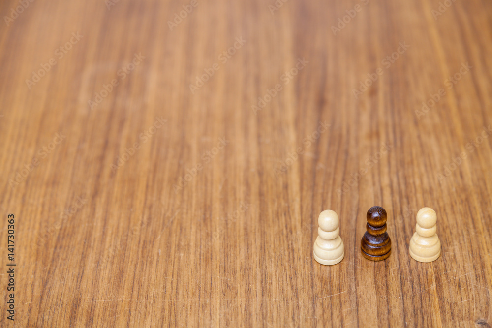 Zwei Weiße Schachfiguren mit einer schwarzen Figur in der Mitte als Symbol für Inklusion, rechts Platz für Text