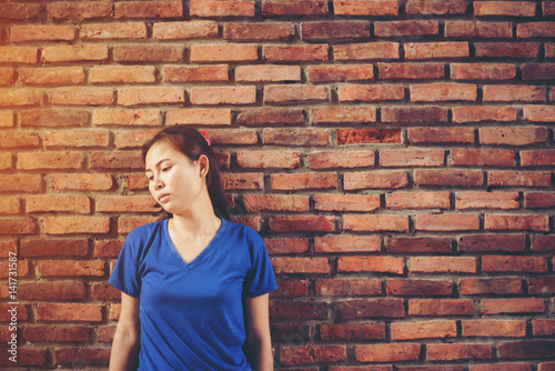 sad woman on the background of an old brick wall