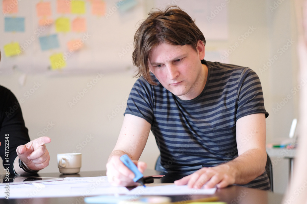 Portrait of a young man at a table at work. Portrait of a young man at a table at work.