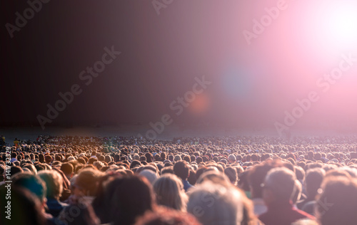 Panoramic photo of large crowd of people. Slow shutter speed motion blur.