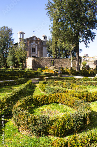 giardino all'italiana davanti ad una chiesa romanica photo