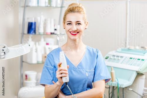 Portrait of female cosmetologist in uniform in the cosmetology office