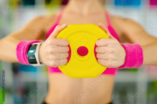 Fitness blonde woman standing with dumbbells back sport