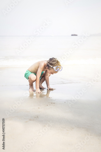 cute little boy with diving glasses at the beach