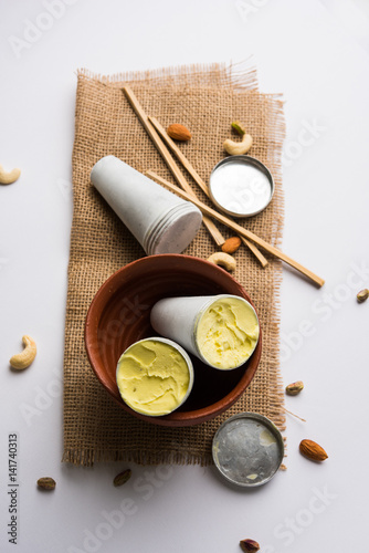 rajasthani home made ready to eat kulfi - safron flavoured or kesariya or keshariya kulfi with pistachio, cashew and almonds, selective focus photo