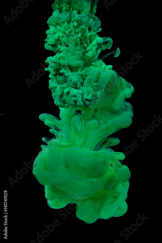 Explosion of green acrylic paint in water on black background.