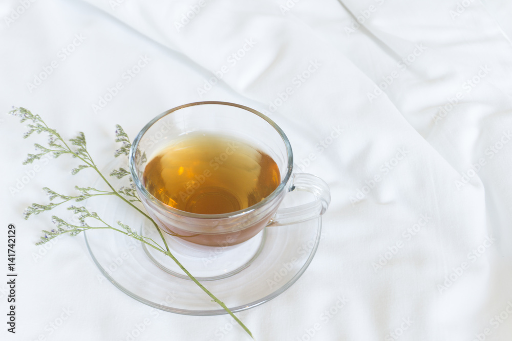 Hot tea cup on the bed with flower Hot tea cup on the bed with flower