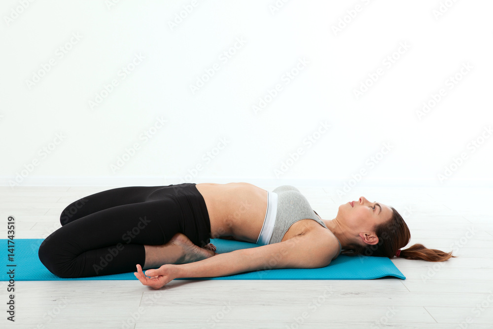 Sport. Fitness Yoga woman. Beautiful middle-aged woman doing yoga poses. Concept people are workout in yoga, training in sports clothes in home interior