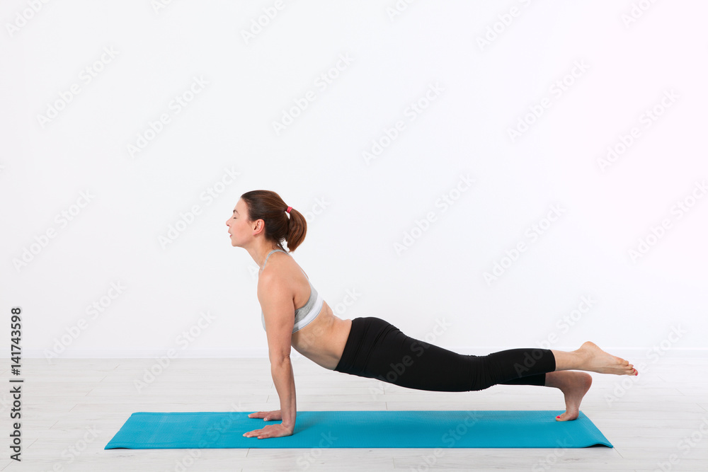 Sport. Fitness Yoga woman. Beautiful middle-aged woman doing yoga poses. Concept people are workout in yoga, training in sports clothes in home interior