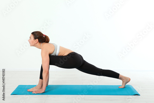 Sport. Fitness Yoga woman. Beautiful middle-aged woman doing yoga poses. Concept people are workout in yoga, training in sports clothes in home interior