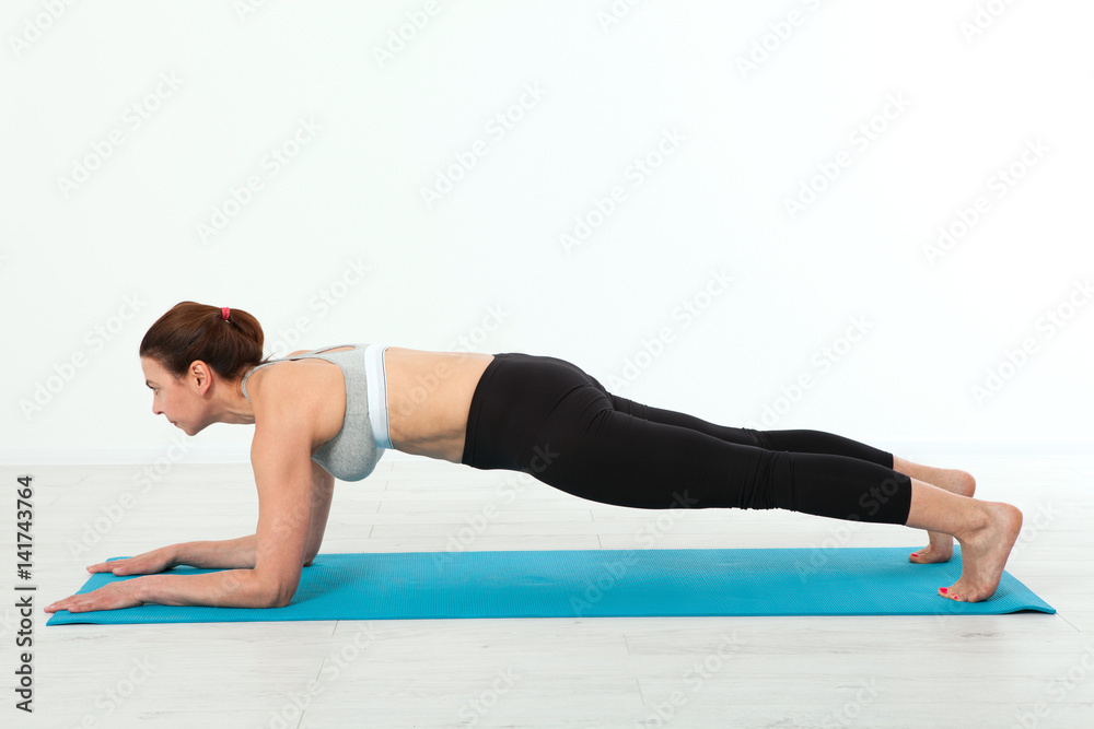 Sport. Fitness Yoga woman. Beautiful middle-aged woman doing yoga poses. Concept people are workout in yoga, training in sports clothes in home interior Sport. Fitness Yoga woman. Beautiful middle-aged woman doing yoga poses. Concept people are workout in yoga, training in sports clothes in home interior